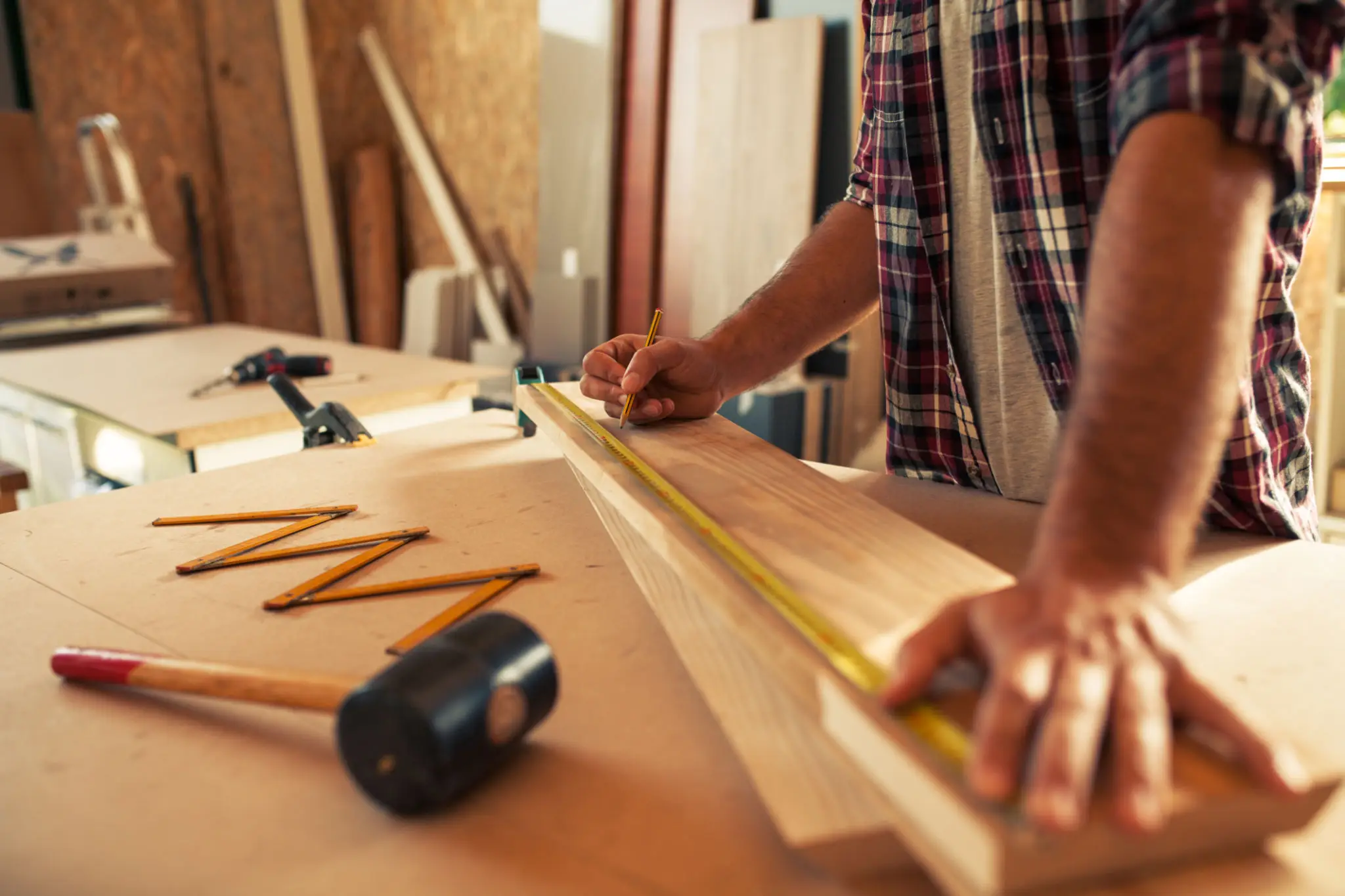 Woodworker marking board in workshop